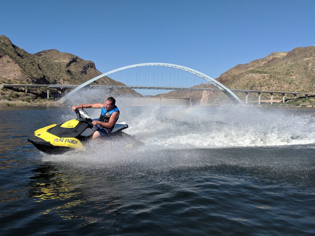 A man is riding on the water with a jet ski.